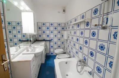 a blue and white bathroom with two sinks and a toilet at Appartamenti Katinanna in Alleghe