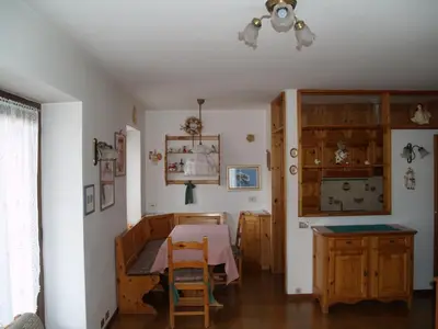 a dining room with a table and a table and chairs at Appartamenti Katinanna in Alleghe
