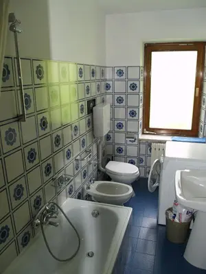 a bathroom with a tub and a toilet and a sink at Appartamenti Katinanna in Alleghe