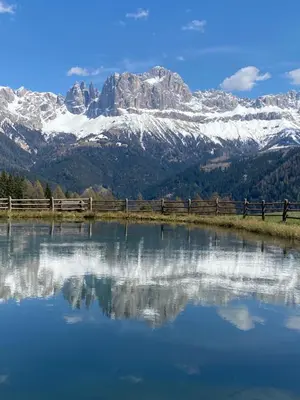 a reflection of a snow covered mountain in a lake at Schneiderhaus in Bagni di Lavina Bianca