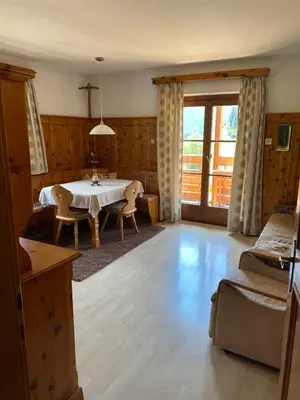 a living room with a table and a balcony at Schneiderhaus in Bagni di Lavina Bianca