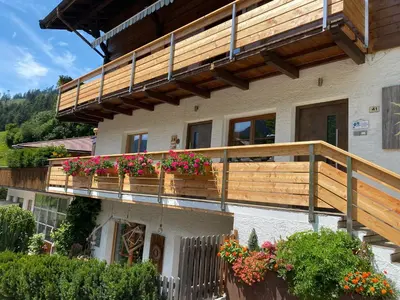 a house with a balcony with flowers on it at Schneiderhaus in Bagni di Lavina Bianca
