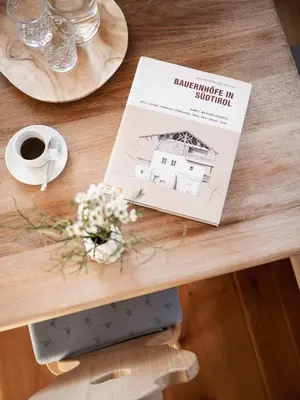 a book sitting on top of a table with a cup of coffee at Radhof in Villandro