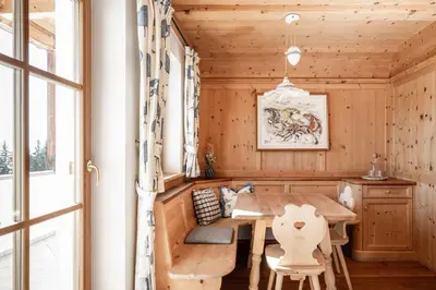 a dining room with a wooden table and chairs at Radhof in Villandro