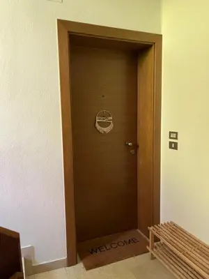 a hallway with a brown door with a sign on it at M&M Apartment in Perca
