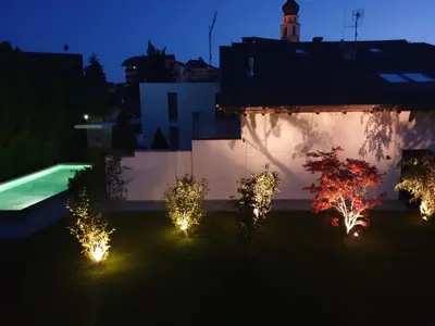 a backyard lit up at night with christmas lights at Residence Baumgartner in Fiè