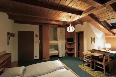 a bedroom with a bed and a desk and a room at Residence Baumgartner in Fiè