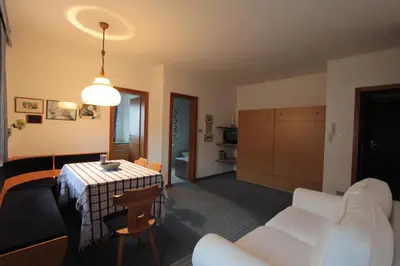 a living room with a table and white furniture at Residence Baumgartner in Fiè