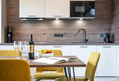 a table with a bottle of wine and a bowl of fruit at Appartements Panorama in Fiè
