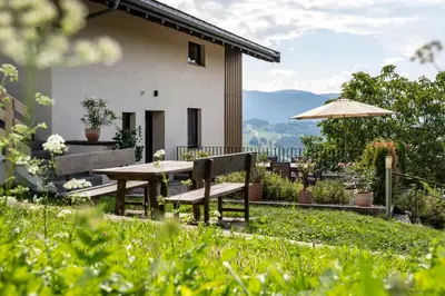 a patio with a table and chairs and an umbrella at Appartements Panorama in Fiè