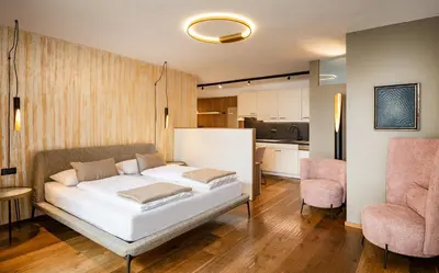 a bedroom with a white bed and a kitchen at Appartements Panorama in Fiè