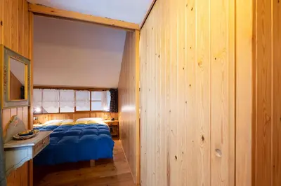a bedroom with a bed with a blue comforter at Cesa Molin in Campitello di Fassa