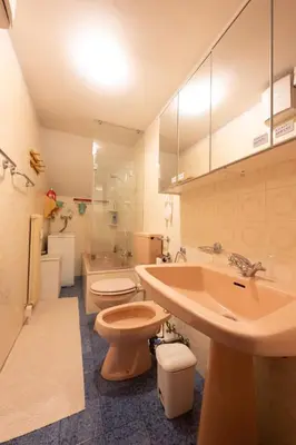 a bathroom with two toilets and a sink and a tub at Cesa Molin in Campitello di Fassa