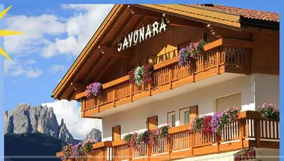 a building with flowers on the balconies of it at Garni Sayonara in Moena