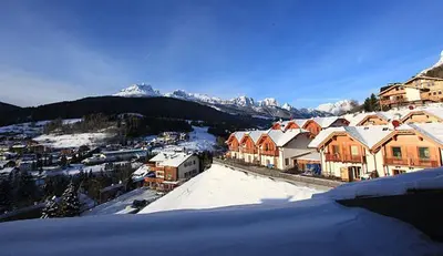 a group of houses with snow on the roofs at Garni Sayonara in Moena
