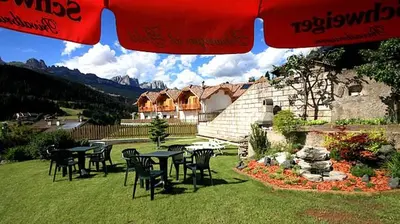 a group of tables and chairs in a yard at Garni Sayonara in Moena