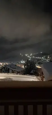 a view of a city at night with snow and lights at Garni Sayonara in Moena
