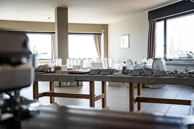 a dining room with a long table with chairs at PanoramaHotel Penegal in Mendola