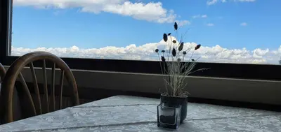 a table with a vase on a table with a window at PanoramaHotel Penegal in Mendola