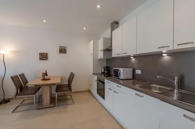 a kitchen with white cabinets and a wooden table at Residence Weinberg 8 in Nalles
