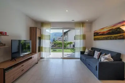 a living room with a blue couch and a tv at Residence Weinberg 8 in Nalles