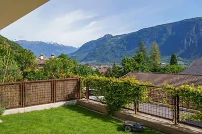 a garden with a fence and mountains in the background at Residence Weinberg 8 in Nalles