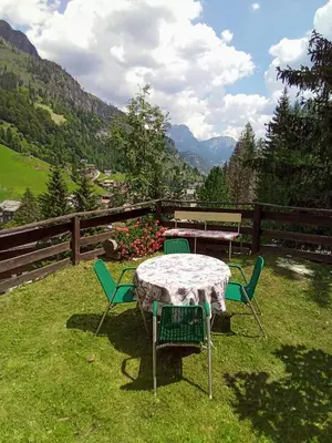 a table and chairs in the grass with a view at Il nido (Cica) in Sottoguda