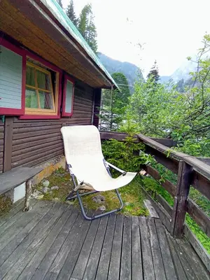 a white rocking chair sitting on a wooden deck at Il nido (Cica) in Sottoguda