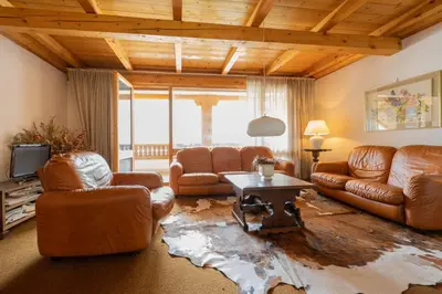 a living room with leather couches and a table at Cesa Monti pallidi 1 in Canazei
