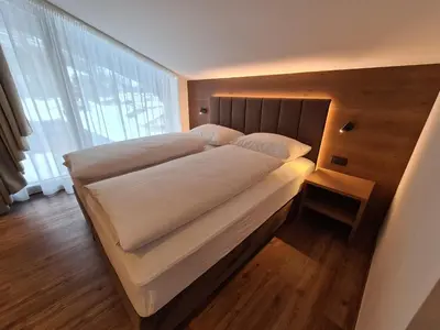 a bed in a room with a large window at Chalet Gravina in Ortisei