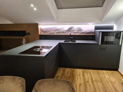 a kitchen with a sink and a counter with chairs at Chalet Gravina in Ortisei