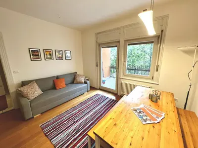 a living room with a couch and a table at Bolzano with a view in Bolzano