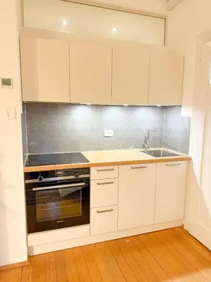 a kitchen with white cabinets and a sink at Bolzano with a view in Bolzano