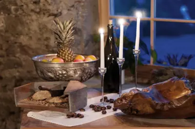 a table topped with a bowl of fruit and candles at Messnerwirt Onach in San Lorenzo di Sebato