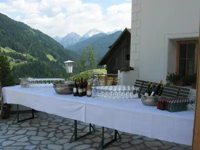 a white table with wine glasses and wine bottles at Messnerwirt Onach in San Lorenzo di Sebato