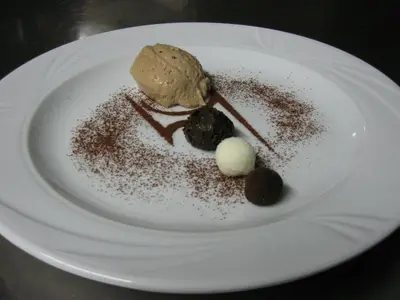 a white plate with a dessert with chocolate on it at Messnerwirt Onach in San Lorenzo di Sebato