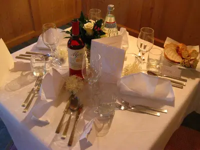 a white table with wine bottles and glasses on it at Messnerwirt Onach in San Lorenzo di Sebato