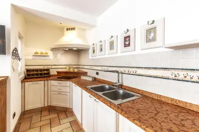 a kitchen with white cabinets and a sink at Valle Filippo in Canazei