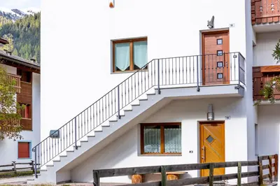 a staircase leading up to a house with a wooden door at Valle Filippo in Canazei