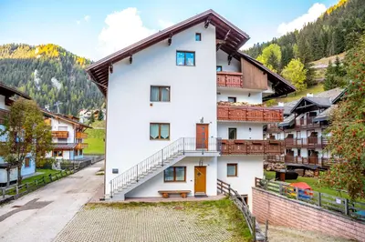 a white building with a staircase in a village at Valle Filippo in Canazei