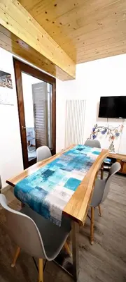 a dining room table with a blue table cloth on it at Trilocale mansardato nel cuore della Val Di Fiemme in Ziano di Fiemme