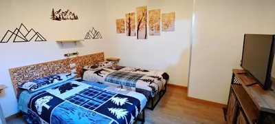 a room with two beds and a flat screen tv at Trilocale mansardato nel cuore della Val Di Fiemme in Ziano di Fiemme