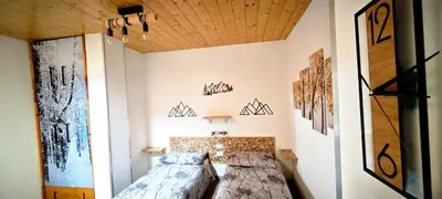 a small bedroom with a bed and artwork on the wall at Trilocale mansardato nel cuore della Val Di Fiemme in Ziano di Fiemme