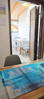 a reflection of a room with a table and a dining room at Trilocale mansardato nel cuore della Val Di Fiemme in Ziano di Fiemme