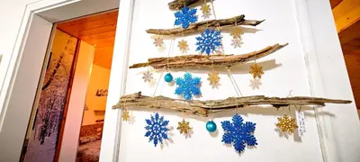 a christmas tree made out of driftwood and blue ornaments at Trilocale mansardato nel cuore della Val Di Fiemme in Ziano di Fiemme