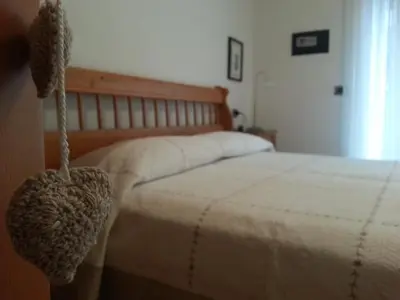 a bedroom with a bed with a wooden head board at Valle Maura in Canazei