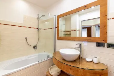 a bathroom with a sink and a tub and a mirror at Valle Maura in Canazei