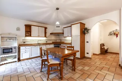 a large kitchen with a wooden table and chairs at Valle Maura in Canazei