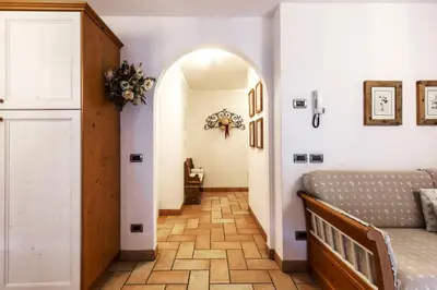 a hallway with an archway and a bed in a room at Valle Maura in Canazei