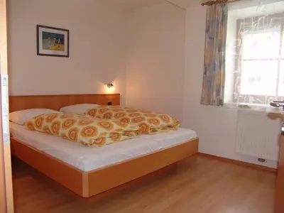a bedroom with a bed with a blanket on it at Appartement Gandler in Valdaora